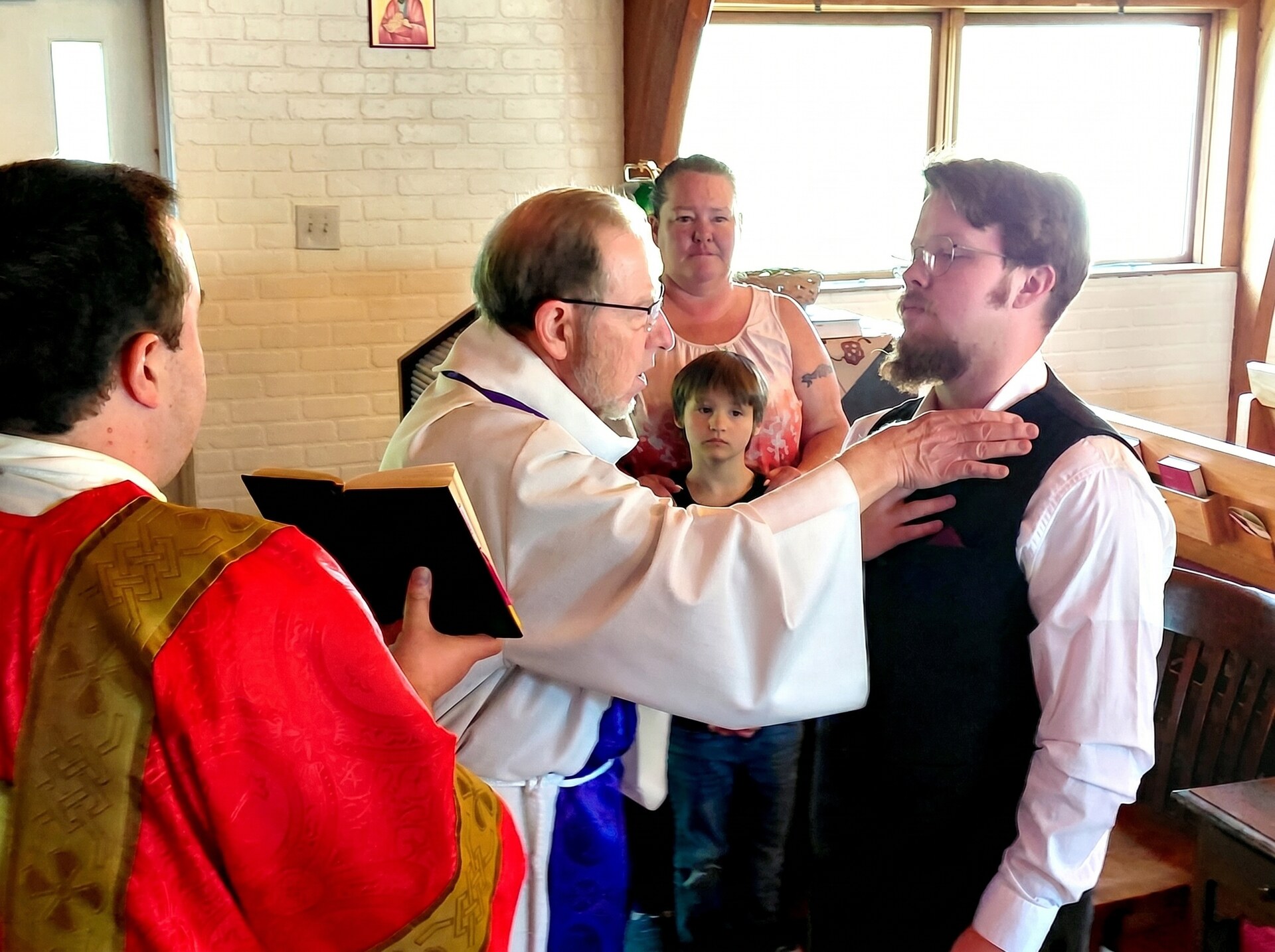 The priest lays his hand on the newly baptized and signs him with the Cross